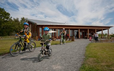 Family cycling away from the visitor centre
