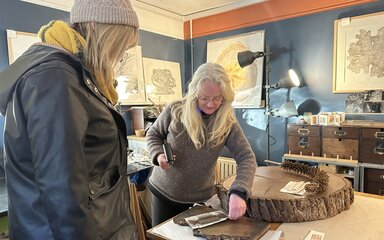 Two women in an artists studio looking at nature inspired work