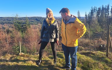 man and woman smiling in  forest on a sunny winter day