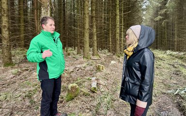 A man and woman talking in a winter forest