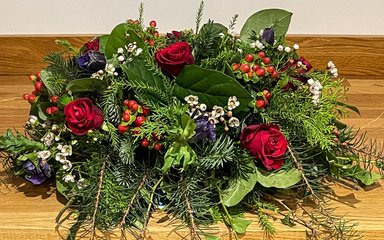 A Christmas floral arrangement on a wooden table