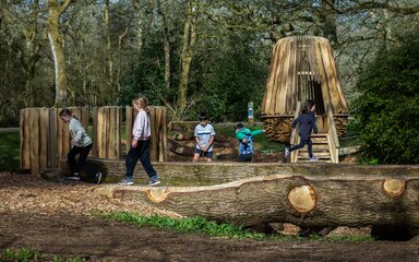 A natural play area with wooden tree balance beams