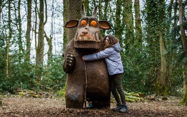 Young girl hugging the Gruffalo Sculpture at Westonbirt 