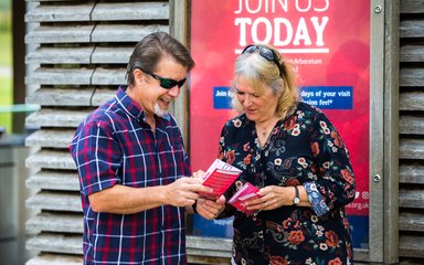 man and woman looking at Friends of Westonbirt Arboretum leaflet