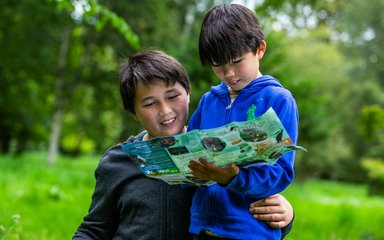 2 young brothers look at a play map
