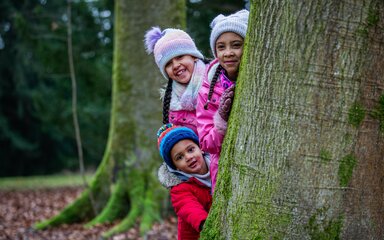 Family wrapped around tree trunk