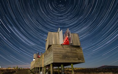 Kielder Observatory at night surrounded by stars