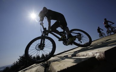 Mountain biker riding over timber flyover at Kielder