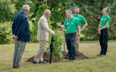 HRH King Charles lll and a Forestry England staff by recently planted tree