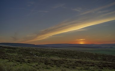 Dark sky sunset over open field