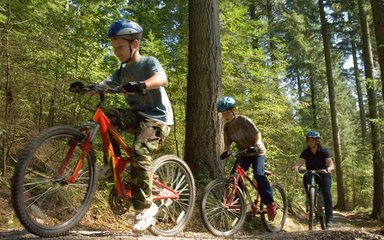 family cycling through the forest