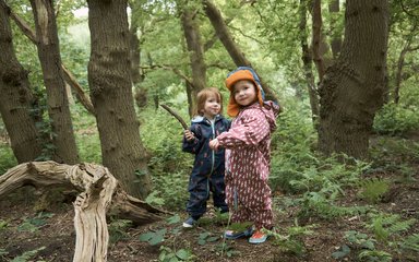 2 children in waterproofs in the forest