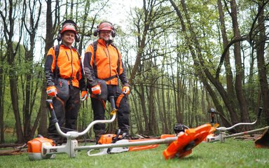 two men in protective clothing in forest