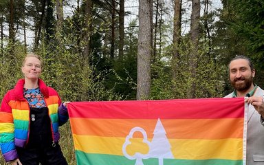 LGBTQ+ Forestry Commission flag being held by 2 people