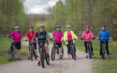 Group of cyclists on forest track smiling