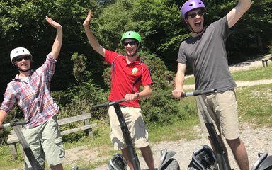 Three guys enjoying Segway in the forest 