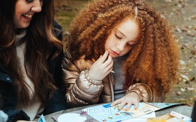 Child and mum looking at an activity sheet