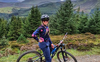 Tess Brown on bike with forest backdrop