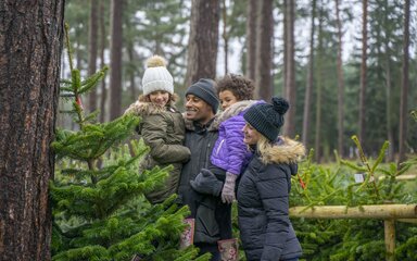 Family standing with christmas tree