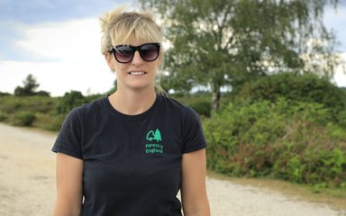 Recreation ranger Amy Howell wearing sunglasses and standing on a footpath in the New Forest