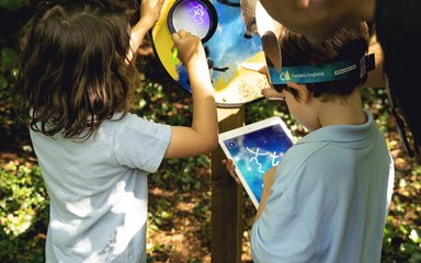 Two boys interact with UV sign and iPad