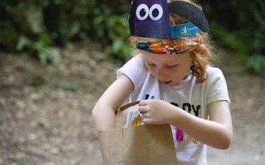 Young girl in shaun ears reaches into pack