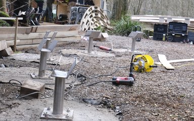 Ground works for a construction site. 5 concrete circles with a steel bracket coming out from the ground.