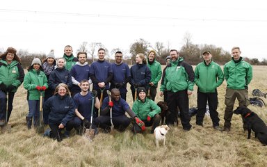 group of people with 2 dogs in a field