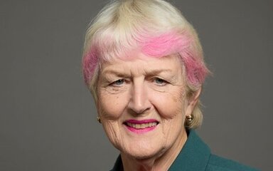 Headshot of a woman with short pale blond hair, tipped in pink.