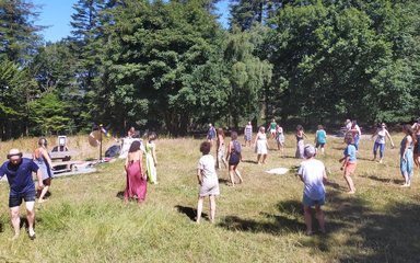 A group of people dancing in a forest clearing.