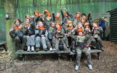 Group of children smiling at a paintballing centre