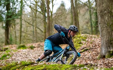 A man on a mountain bike in the forest.