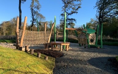 A children's play area consisting of a rope bridge and a raised play area