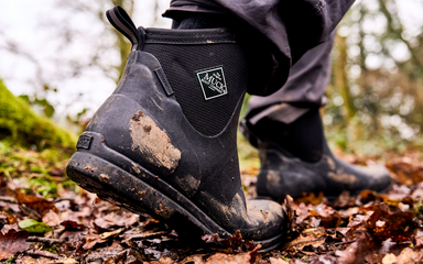 close up of muddy boots walking through forest