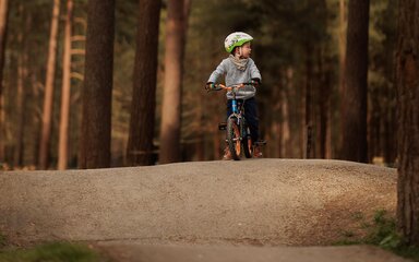 boy rides bike on pump track