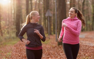 adults on a run on a woodland trail