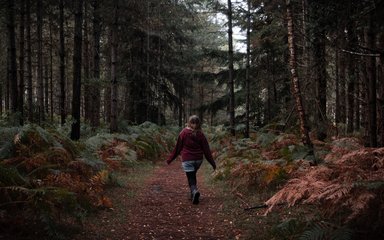 Woman walking through woodlands