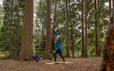 Woman doing yoga pose among the trees