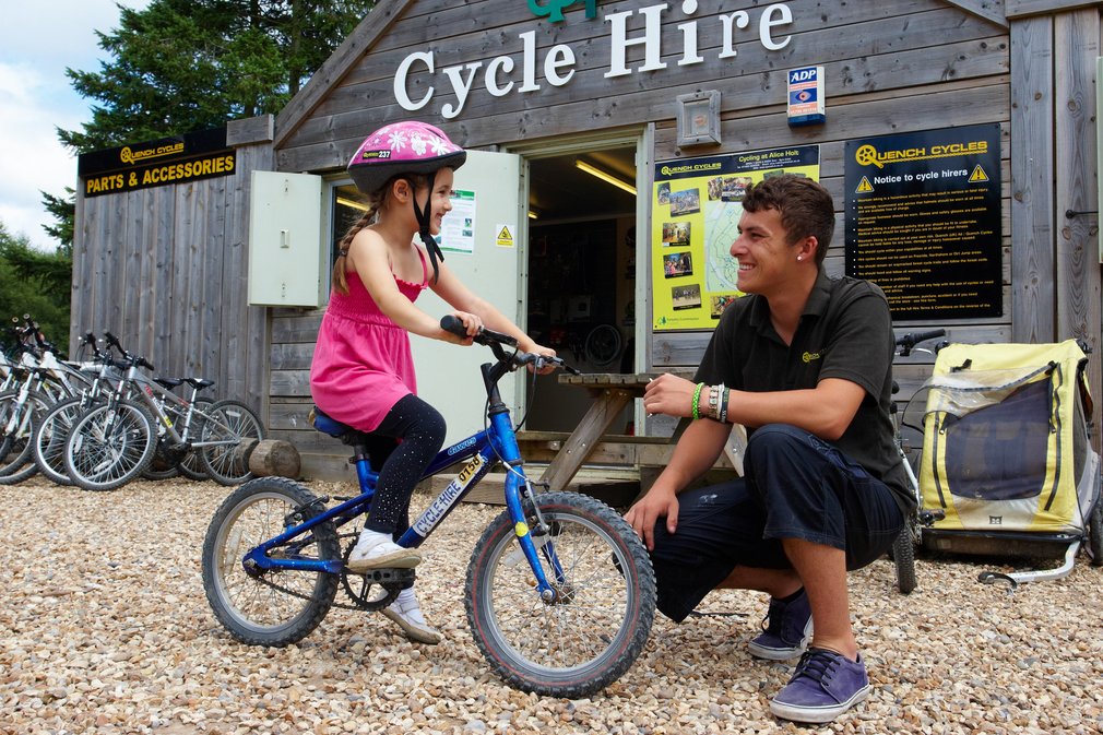Child outside bike hire shop in the woods