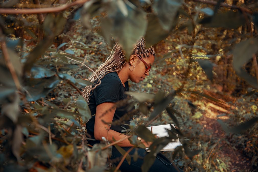 Woman writing on a notepad in the forest