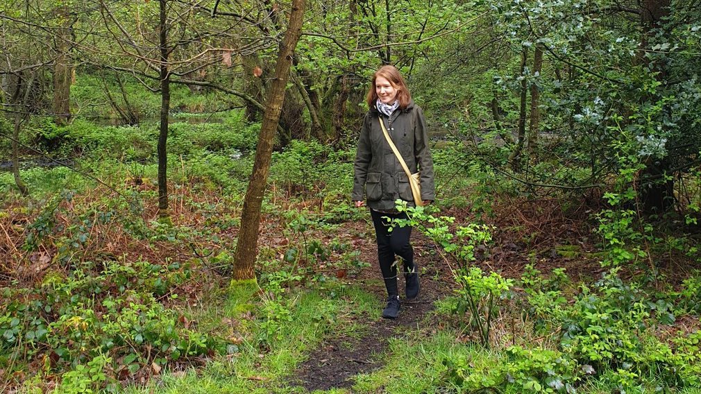 Woman walking in woods footpath