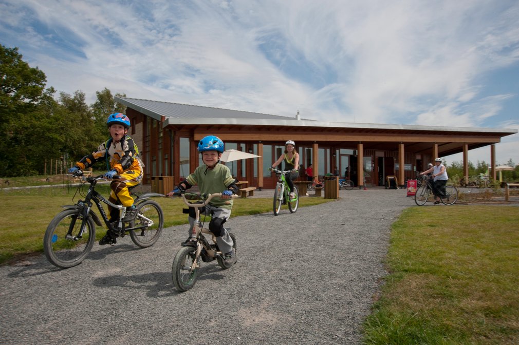 Family cycling away from the visitor centre