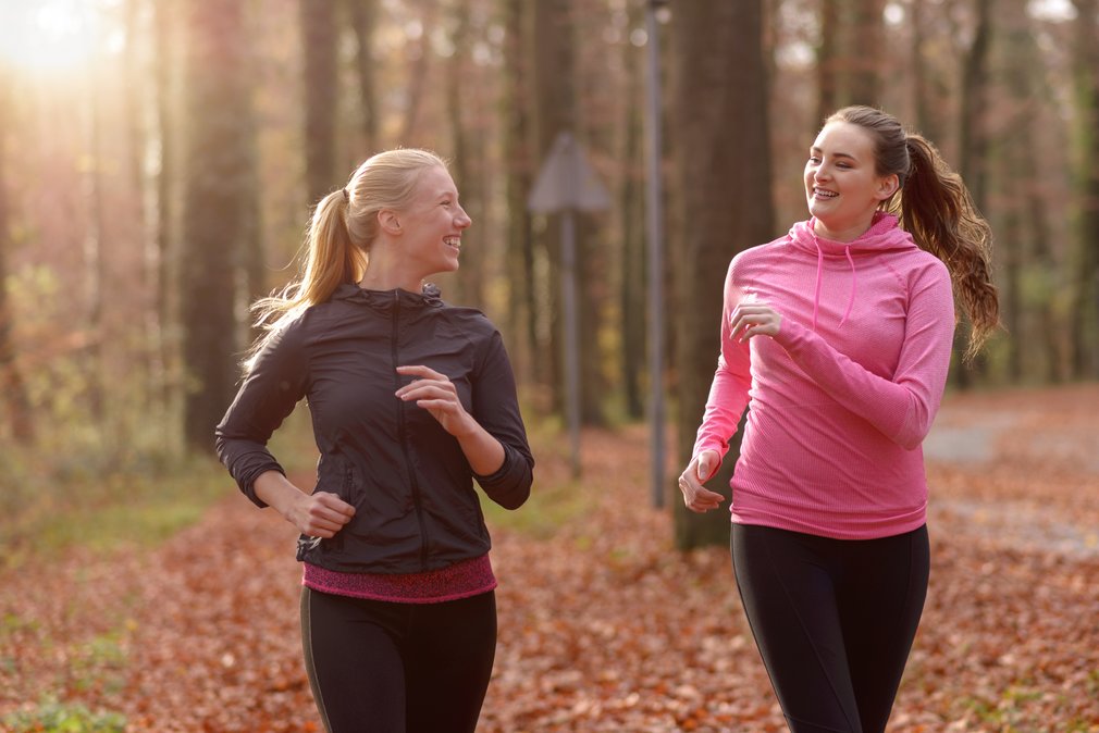 adults on a run on a woodland trail