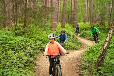 Family cycling on a winding forest path