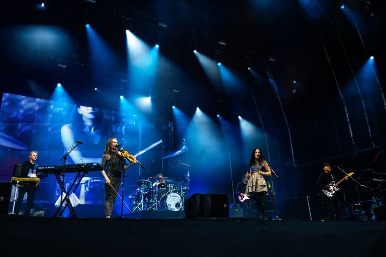 Wide shot of band The Corrs showing four people on stage holding instruments.