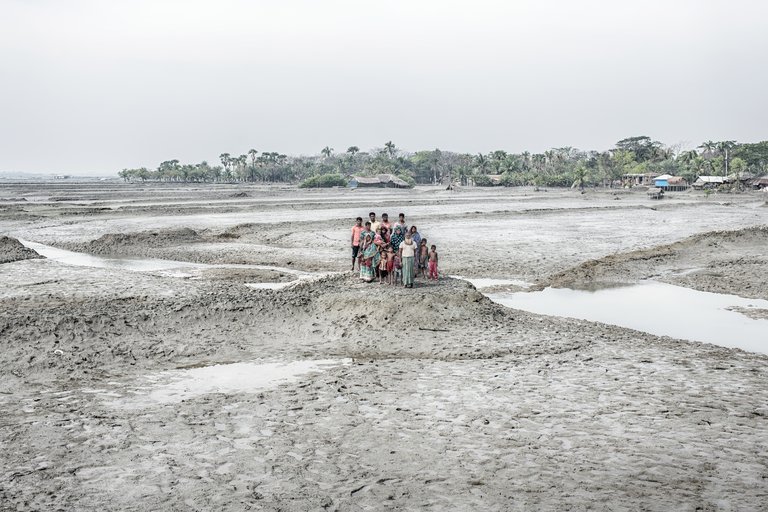 Small group of people in Bangladesh standing on flooded land