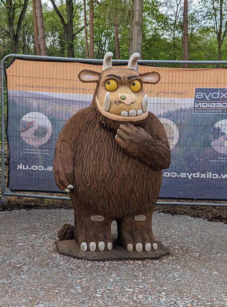 A large wooden carving of The Gruffalo, a fictional monster.