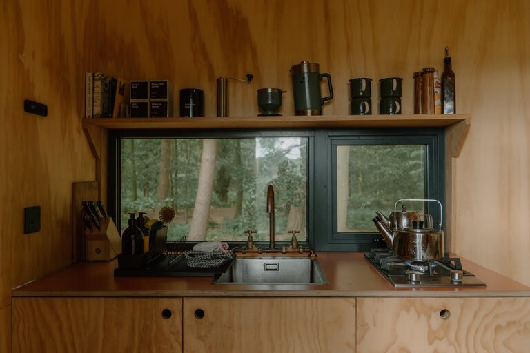 Unyoked cabin interior kitchen area with view out of the window into the woods