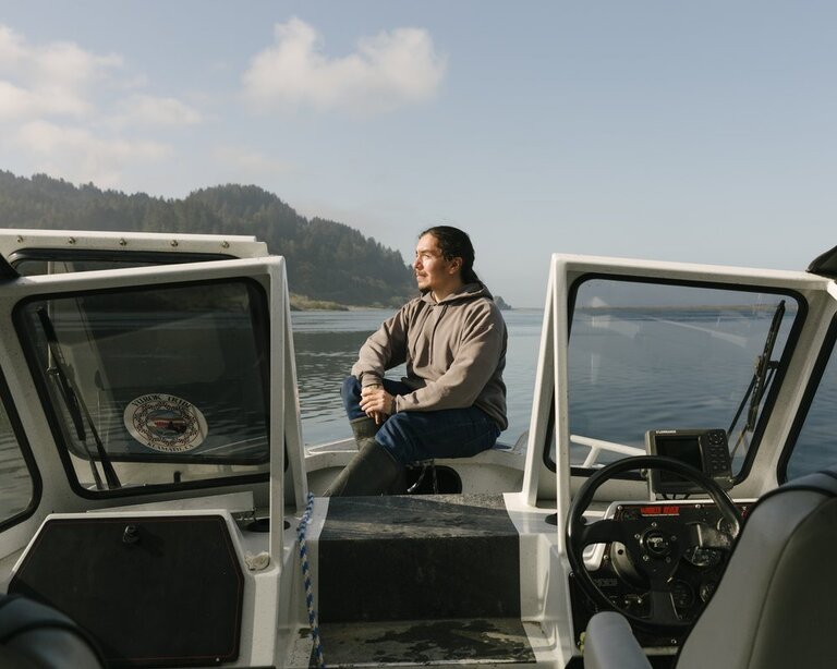 Man on boat with trees in the background