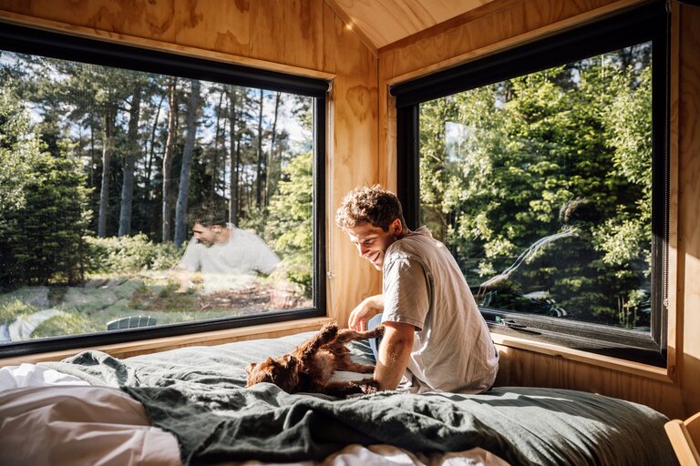 A man sat with his dog in a cabin